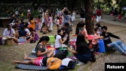 Parents and children relax at a public park, as the country's capital region loosens coronavirus disease (COVID-19) restrictions, in Quezon City, Metro Manila, Philippines, November 2, 2021. (REUTERS/Lisa Marie David)