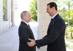 FILE - Russian President Vladimir Putin welcomes Syrian President Bashar al-Assad at the Black Sea resort of Sochi, Russia, May 17, 2018.