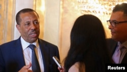 FILE - Libya's Prime Minister Abdullah al-Thinni (L) speaks to reporters in Abu Dhabi, Sept. 10, 2014.