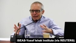 រូប​ឯកសារ៖ លោក Sean Turnell ពិភាក្សា​អំពី​កំណែទម្រង់​សេដ្ឋកិច្ច​របស់​អតីត​រដ្ឋាភិបាល​ដឹកនាំ​ដោយ​គណបក្ស​ NDL នៅ​ក្នុង​បឋកថា​មួយ​នៅ​ប្រទេស​សិង្ហបុរី កាល​ពី​ឆ្នាំ​២០១៨។ (ISEAS-Yusof Ishak Institute/via Reuters) 