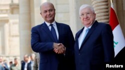 លោក Faud Masum (ខាងស្តាំ) ចាប់ដៃជាមួយប្រធានាធិបតីថ្មីរបស់អ៊ីរ៉ាក់ លោក Barham Salih នៅ​ក្រុងបាកដាដ ប្រទេស​អ៊ីរ៉ាក់ កាលពីថ្ងៃទី០៣ ខែតុលា ឆ្នាំ២០១៨។ 