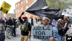 អ្នក​តវ៉ា​ប្រមូល​ផ្តុំ​គ្នា​នៅ​ខាង​ក្រៅ​ស្ថានីយ៍​ប៉ូលិស​នៅ​ Baltimore មុន​ការ​ដង្ហែ​ក្បូន​សម្រាប់​ Freddie Gray កាលពី​ថ្ងៃទី២៥ ខែមេសា ឆ្នាំ២០១៥។ 