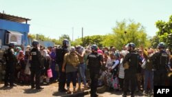 Les gendarmes contiennent des manifestants près de l'aéroport sur l'île de Petite-Terre dans l'océan Indien, Mayotte, le 12 mars 2018.