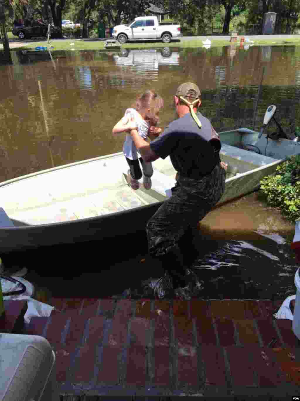Graham Kinchen of St. Amant, Louisiana, takes time off to give his daughter a boat ride &mdash; in their front yard. (D. Kinchen /VOA)