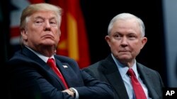 FILE - President Donald Trump sits with Attorney General Jeff Sessions during the FBI National Academy graduation ceremony in Quantico, Va.
