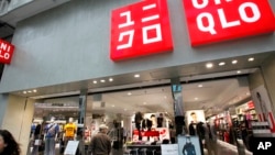 在这张2010年4月7日的照片中，一位路人看着日本东京的优衣库商店。（美联社照片）