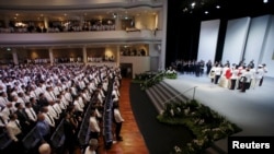 មនុស្ស​ម្នា​ដែល​ចូលរួម​ពិធី​បុណ្យ​សព​របស់​អតីត​មេដឹកនាំ​សិង្ហបុរី Lee Kuan Yew ឈរ​នៅ​មជ្ឈមណ្ឌល​វប្បធម៌​ University Cultural Center នៅ​សាកលវិទ្យាល័យ​ជាតិ​របស់​សិង្ហបុរី​ (National University of Singapore) កាលពី​ថ្ងៃទី២៩ ខែមីនា ឆ្នាំ២០១៥។