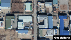 트럭 한 대(아래 붉은 원 안)가 개성공단의 한 공장건물 내부로 통하는 대형 통로에 맞댄 상태로 정차해 있다. 사진 위쪽 도로에는 버스가 달리고 있다.