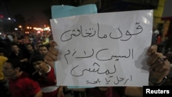 A protester carries a sign that reads "Don't be afraid ..say .. Sissi must leave" while protesters gather in central Cairo shouting anti-government slogans, Egypt, Sept. 21, 2019.