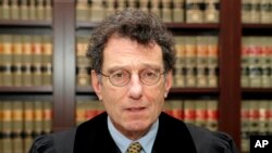 FILE - U.S. District Judge Dan Polster poses for a portrait in his office in Cleveland, Ohio, Jan. 11, 2018. He rejected efforts by drugmakers to dismiss claims they caused the nation's opioid crisis, clearing the way for a scheduled landmark trial.