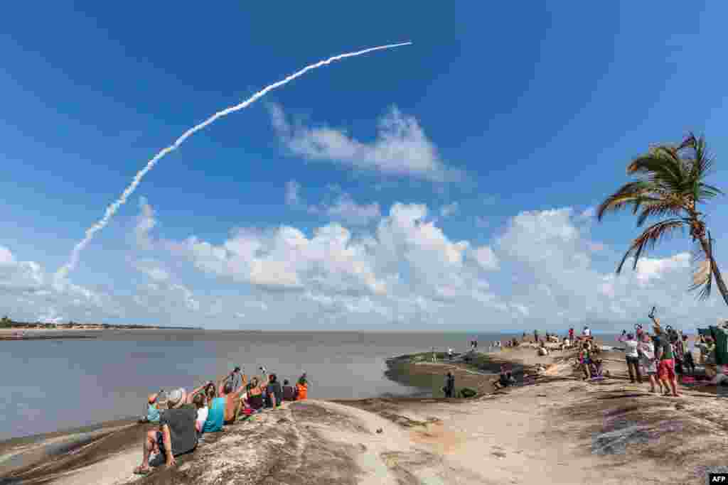 Para turis memotret peluncuran roket Ariane 5 dari pangkalan peluncuran badan antariksa Eropa (ESA) di Kourou, Guyana Perancis.