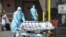 Bodies are moved to a refrigeration truck serving as a temporary morgue at Wyckoff Hospital in the Borough of Brooklyn on April 6, 2020 in New York.