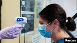 Seorang perawat Rumah Sakit Oro Valley diperiksa suhu tubuhnya sebelum disuntik uji coba vaksin Covid-19 di University of Arizona, Tucson, Arizona, AS, 10 Juli 2020.