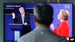 A man watches a TV screen showing the live broadcast of the U.S. presidential debate between Democratic presidential candidate Hillary Clinton and Republican presidential candidate Donald Trump, at Seoul Railway Station in Seoul, South Korea, Sept. 27, 20