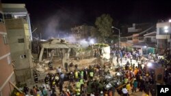 FILE - Volunteers and rescue workers search for children trapped inside at the collapsed Enrique Rebsamen school in Mexico City, Sept. 19, 2017. 