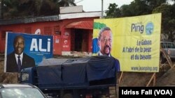 Les affiches de la campagne électorale du président gabonais sortant Ali Bongo et de son rival Jean Ping de l’opposition, sont côte-à-côte, à Libreville, 26 août 2016. (VOA/Idriss Fall) 