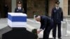 Israel's President Shimon Peres (C) lays a wreath near the flag draped coffin of former Israeli prime minister Ariel Sharon as he lies in state at the Knesset, Israel's parliament, in Jerusalem, Jan. 12, 2014. 