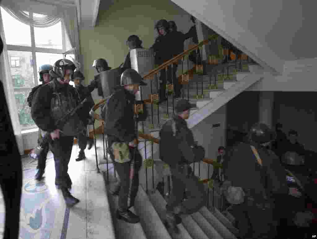 A group of Ukrainian police officers leave the administration building which has been captured by Pro-Russian activists in the center of Luhansk, Ukraine, April 29, 2014.
