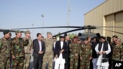 Presiden Afghanistan Ashraf Ghani, tengah, berpose bersama pejabat militer AS dan Afghanistan saat penerimaan dua helikopter Black Hawk dari pemerintah AS, di Lapangan Udara Kandahar, Afghanistan, 7 Oktober 2017.