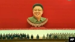 A Spanish Civil Guard officer (L) throws a sandwich to African migrants sitting at the top of a border fence during an attempt to cross into Spanish territory, between Morocco and Spain&#39;s north African enclave of Melilla.