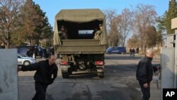 Guards close the barrier of the Harmanli registration center as Bulgarian army soldiers are deployed in Harmanli, Bulgaria, Nov. 25, 2016. Hundreds of migrants have been detained after clashes with police at the refugee camp.