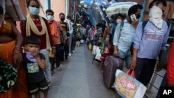 Warga India mengantri untuk melakukan tes Covid-19 di fasilitas yang didirikan di stasiun kereta api untuk menyaring orang-orang yang datang dari luar kota, Ahmedabad, India, Jumat, 18 September 2020. (Foto: AP)