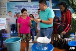 คาร์ลิโต เซอร์นัล จ่ายเงินให้กับชาวบ้านที่นำยุงมาส่งให้ทางการ ตามโครงการ "เปโซแลกยุง" ในกรุงมะนิลา 19 ก.พ. 2025