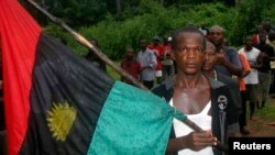 FILE - A man carries the Biafran flag during a parade in Ekwe village, near Enugu in southeastern Nigeria, May 27, 2008. 