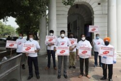 Indian traders hold banners for the banning of Chinese imports during a protest in New Delhi, India, July 3, 2020.