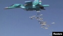 FILE - A still image, taken from video footage and released by Russia's Defense Ministry on Aug. 18, 2016, shows a Russian Sukhoi Su-34 fighter-bomber dropping bombs in the Syrian province of Deir ez-Zor. 