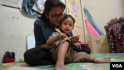 អ្នកស្រី ឡុង គឹមហ៊ាង ភរិយាលោក រ៉ាត់ រត្នមុនី ដែលជាអ្នកបកប្រែភាពយន្តឯកសារ «ម្តាយខ្ញុំ លក់ខ្ញុំ» និងកូនប្រុស កំពុងស្ថិតក្នុងបន្ទប់ជួលមួយក្នុងប្រទេសដែលអ្នកស្រីកំពុងភៀសខ្លួន នៅថ្ងៃទី២៤ ខែកញ្ញា ឆ្នាំ២០១៩។ (កាន់ ​វិច្ឆិកា/VOA)