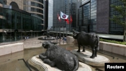 资料照：香港交易广场水牛雕塑前香港证券交易所的旗子在飘扬。（2015年5月28日）