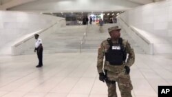 This still image provided by WABC-TV shows law enforcement standing in front of a New York City Subway entrance at the Oculus transportation hub after reports of a suspicious package on a subway platform in New York on Aug. 16, 2019.