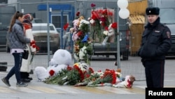 Ljudi polažu cvijeće na improvizirani spomenik žrtvama pucnjave kod koncertne dvorani u blizini Moskve