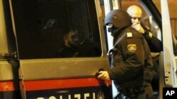 A masked police officers looks into a police car outside a church in Vienna, Austria, Thursday, Dec. 27, 2018. First police reports indicated an armed robbery. 