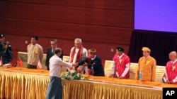 Presiden Myanmar Thein Sein berjabat tangan dengan pemimpin organisasi etnis dalam penandatangan perjanjian perdamaian di Myanmar International Convention Center, Kamis, 15 Oktober 2015 di Naypyitaw, Myanmar (Foto: AP Photo/Aung Shine Oo).