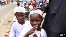 Des frères jumeaux, Salim et Mahamadou Cisse, près de leur mère alors qu’ils mendient sur un marché à Abobo, dans la banlieue d’Abidjan, le 6 septembre 2018.