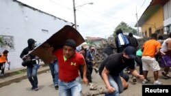 Les manifestants se mettent à l'abri alors que la police leur tire dessus lors d'une manifestation contre le gouvernement du président nicaraguayen Daniel Ortega à Masaya, au Nicaragua, le 19 juin 2018.