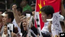 Para demonstran Tiongkok meneriakkan semboyan kemarahan anti Jepang sambil mengibarkan bendera nasional Tiongkok. 