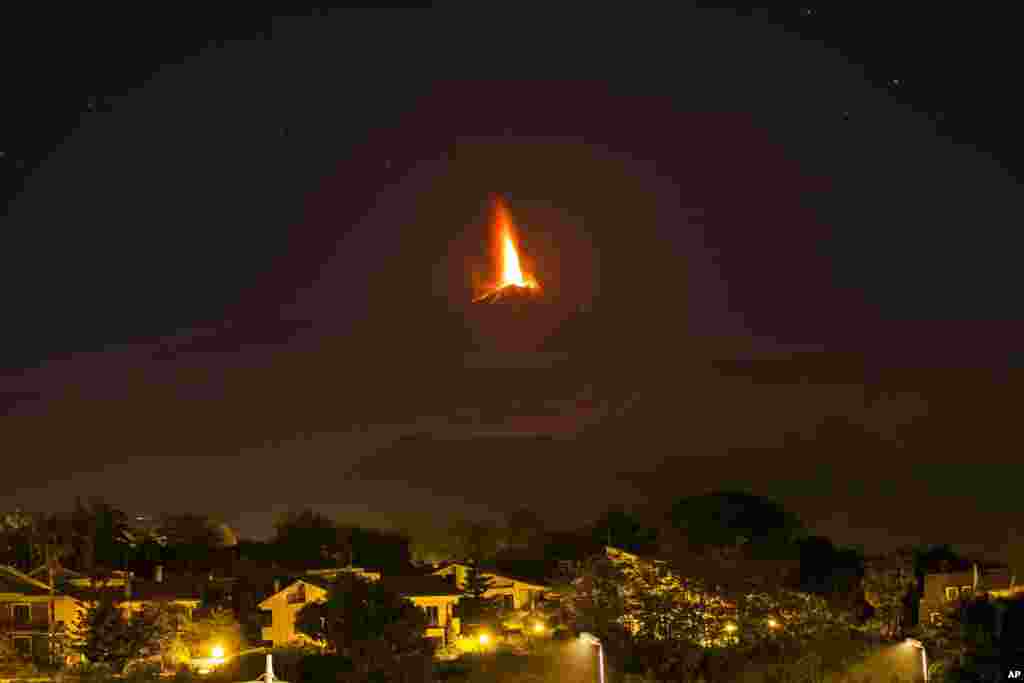Lava tampak mengalir selama letusan Gunung berapi Etna, terlihat dari desa Viagrande, dekat kota Catania, pulau Sisilia, Italia (26/10). 