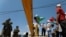 Demonstrators hold Palestinian flags in front of Israeli soldiers during a protest against the United Arab Emirates' deal with Israel to normalize relations, in Haris near Salfit in the Israeli-occupied West Bank, Aug. 14, 2020.