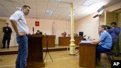 Alexei Navalny (kiri), pemimpin oposisi Rusia, memberikan keterangan di pengadilan Kirov, Rusia (Foto: dok). Jaksa pemerintah Rusia telah meminta sebuah pengadilan agar menuntut Navalny atas tuduhan penggelapan dan menghukumnya enam tahun penjara, Jumat (5/7). 