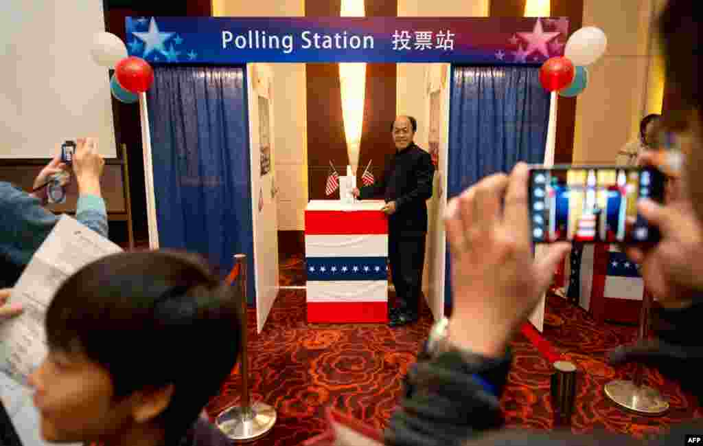 People try out a mock polling station at a hotel during a US presidential election results event organized by the US embassy in Beijing, November 7, 2012.