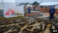 People stand at the entrance of Elwa hospital, which is run by the non-governmental French organization Medecins Sans Frontieres (Doctors without Borders), in Monrovia, Liberia, Sept. 7, 2014.