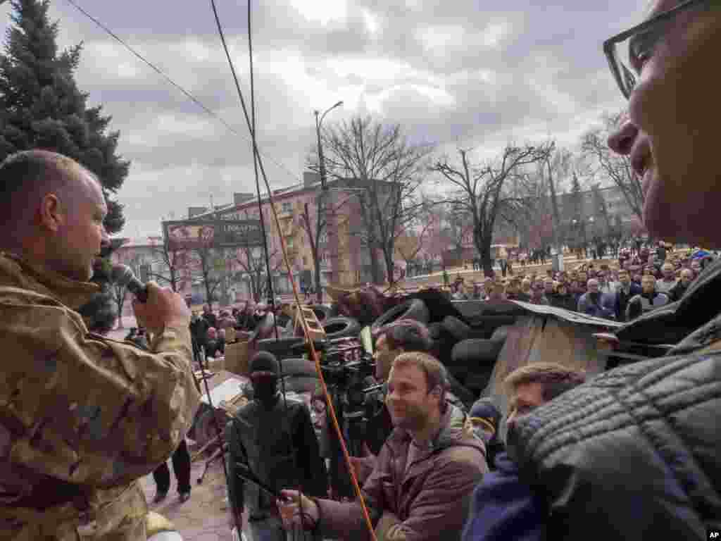 A pro-Russian activist speaks to other protesters at barricades in front of a security service regional office in Luhansk, Ukraine, April 9, 2014.
