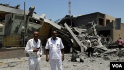 Polisi Libya memeriksa gedung yang hancur akibat serangan udara NATO di Tripoli (16/6).