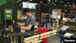 FILE - A production line employee works at the AMES Companies shovel manufacturing factory in Camp Hill, Pennsylvania, June 29, 2017.