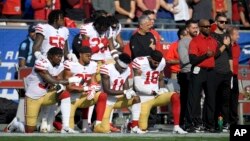 FILE - Members of the San Francisco 49ers kneel during the national anthem before an NFL football game against the Los Angeles Rams, Dec. 31, 2017, in Los Angeles. 