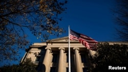 Bendera Amerika berkibar di luar Gedung Departemen Kehakiman AS di Washington, AS, 15 Desember 2020. (Foto: REUTERS/Al Drago)