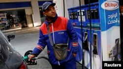 A gas station attendant pumps fuel into a customer's car at a gas station in Tunis, Tunisia, March 31, 2018.